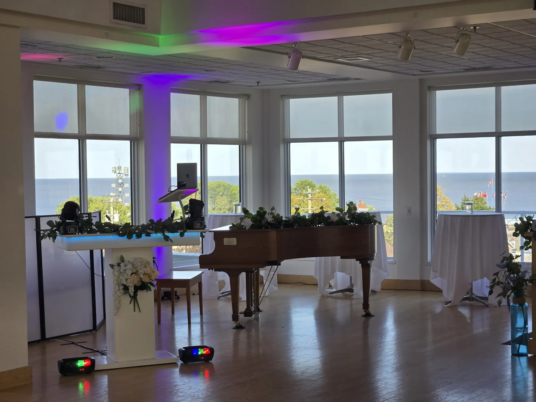 The WAVE DJ table set up for a wedding, lit in purple and green